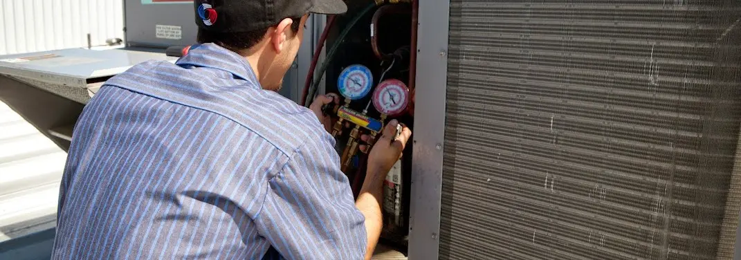 HVAC technician servicing a condenser unit in Alcoa